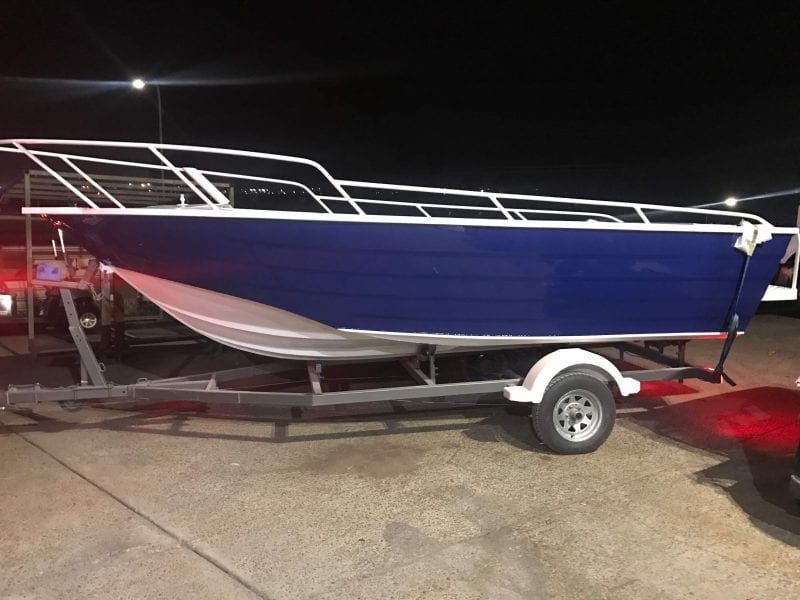 a blue and white boat is on a trailer .