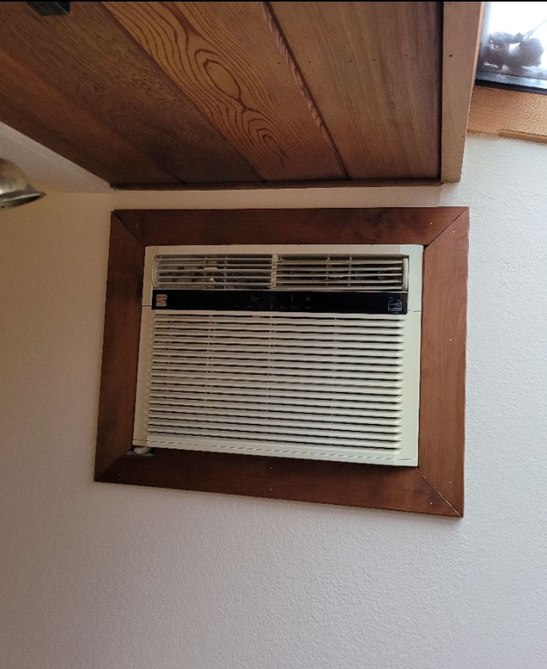 A window air conditioner with a wooden frame