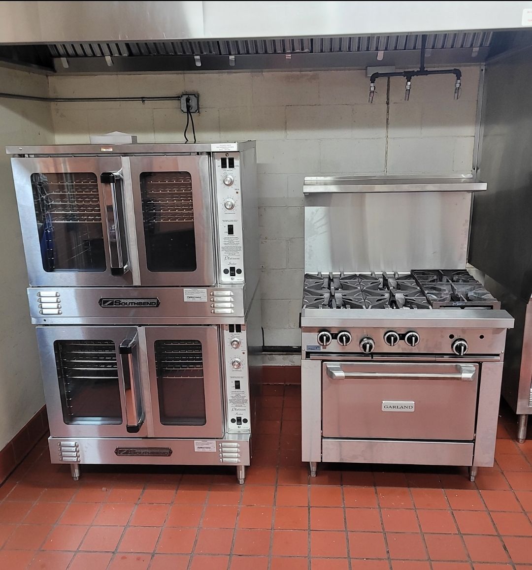 Two stainless steel ovens are stacked on top of each other in a kitchen
