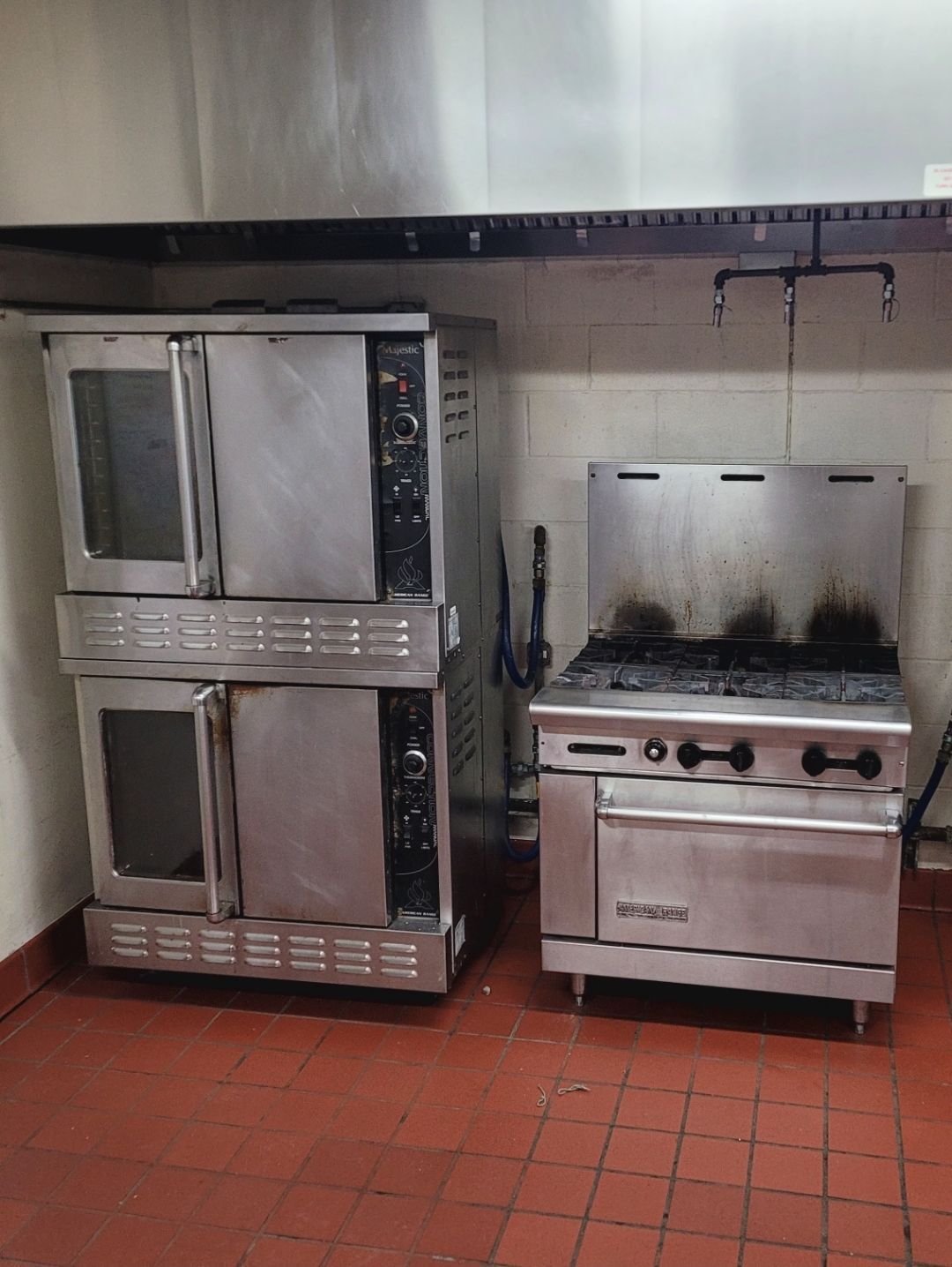 A kitchen with two stainless steel ovens and a stove