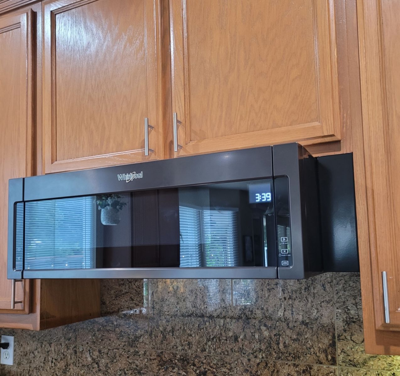 A whirlpool microwave is above a counter in a kitchen