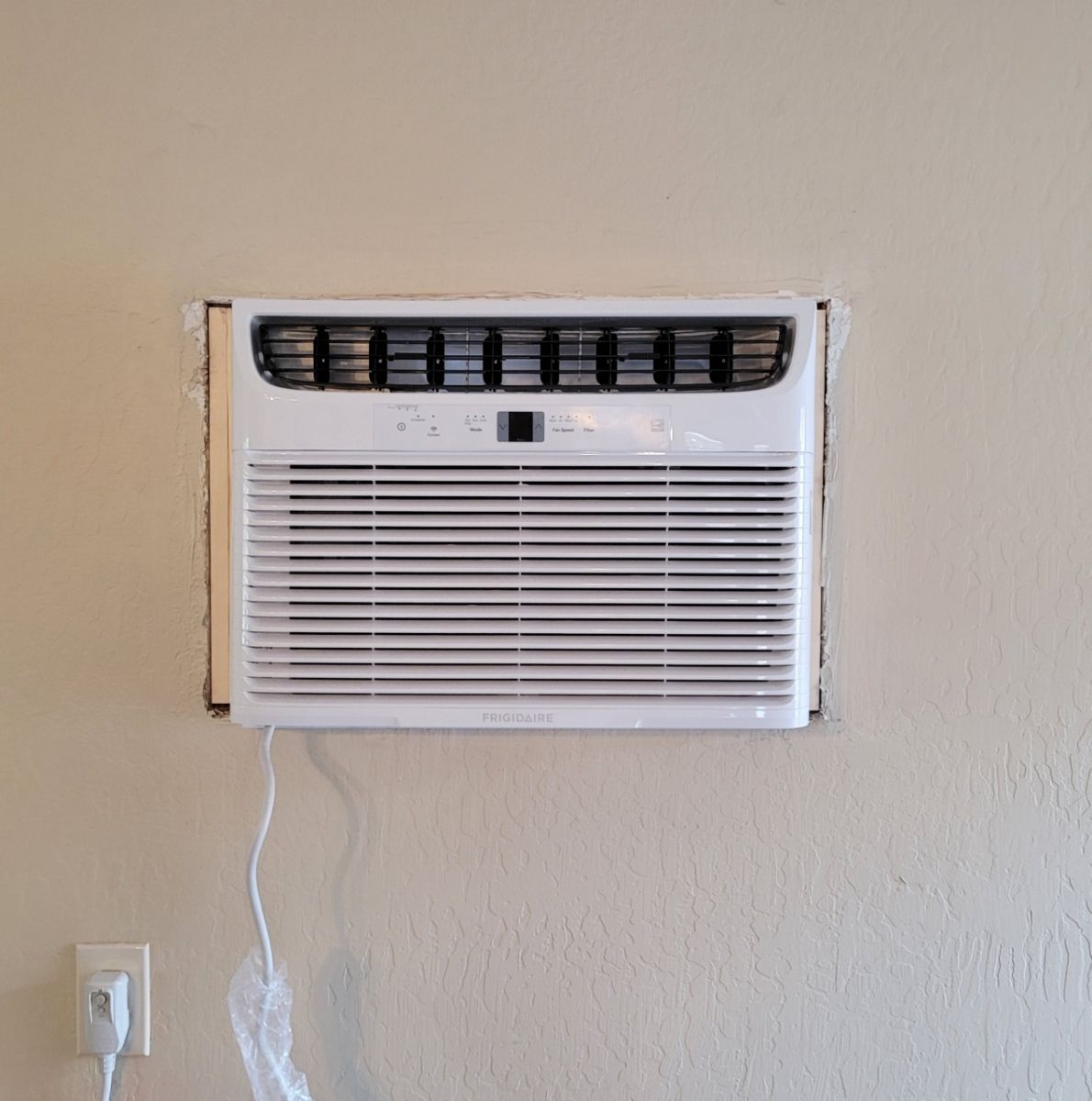 A white air conditioner is hanging on a wall.