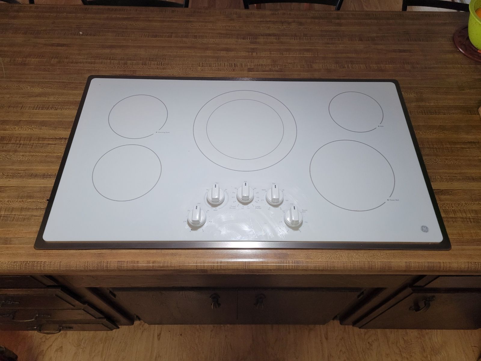 A white stove top oven is sitting on top of a wooden counter.