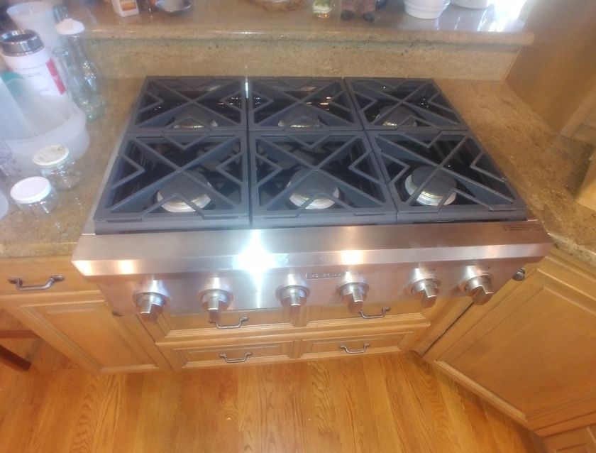 A stove top oven in a kitchen with wooden cabinets