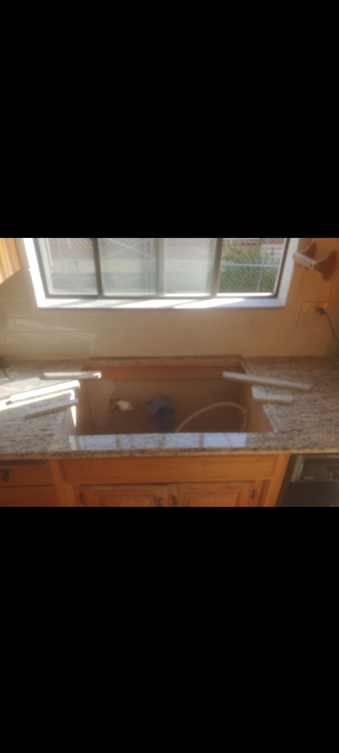 A kitchen counter with a sink and a window.