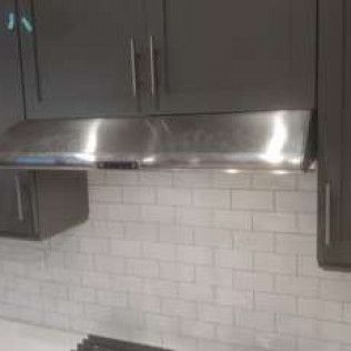 stainless range hood in black cabinet