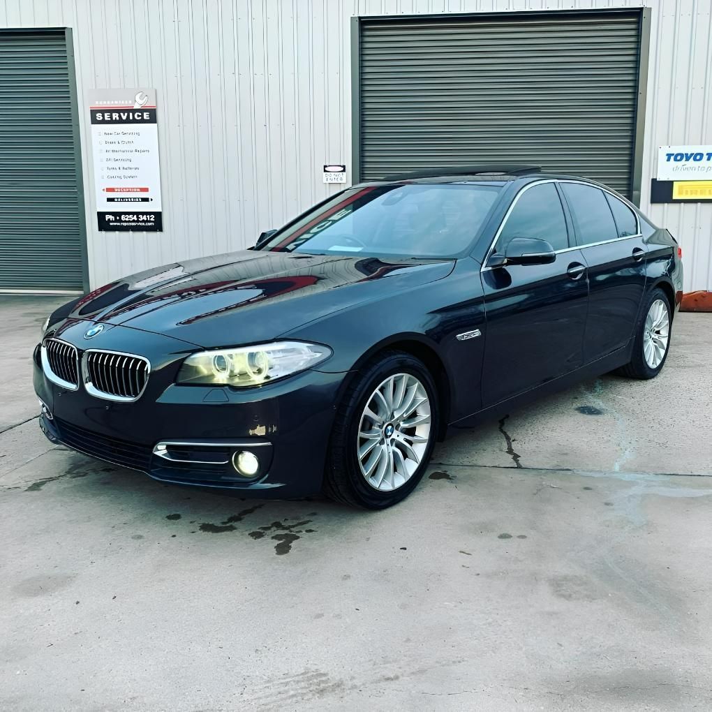A Black BMW Is Parked in Front of A Garage — Platinum Hand Car Wash & Detailing in Belconnen, ACT