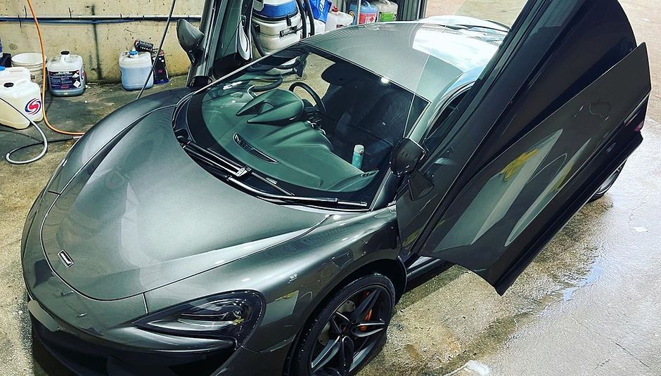 A Gray Sports Car is Parked in a Garage With Its Doors Open — Platinum Hand Car Wash & Detailing in Belconnen, ACT