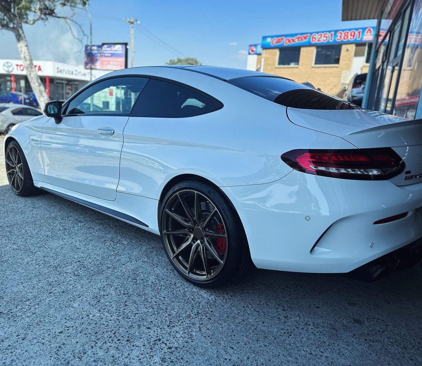 A white sports car is parked in front of a building — Platinum Hand Car Wash & Detailing in Belconnen, ACT