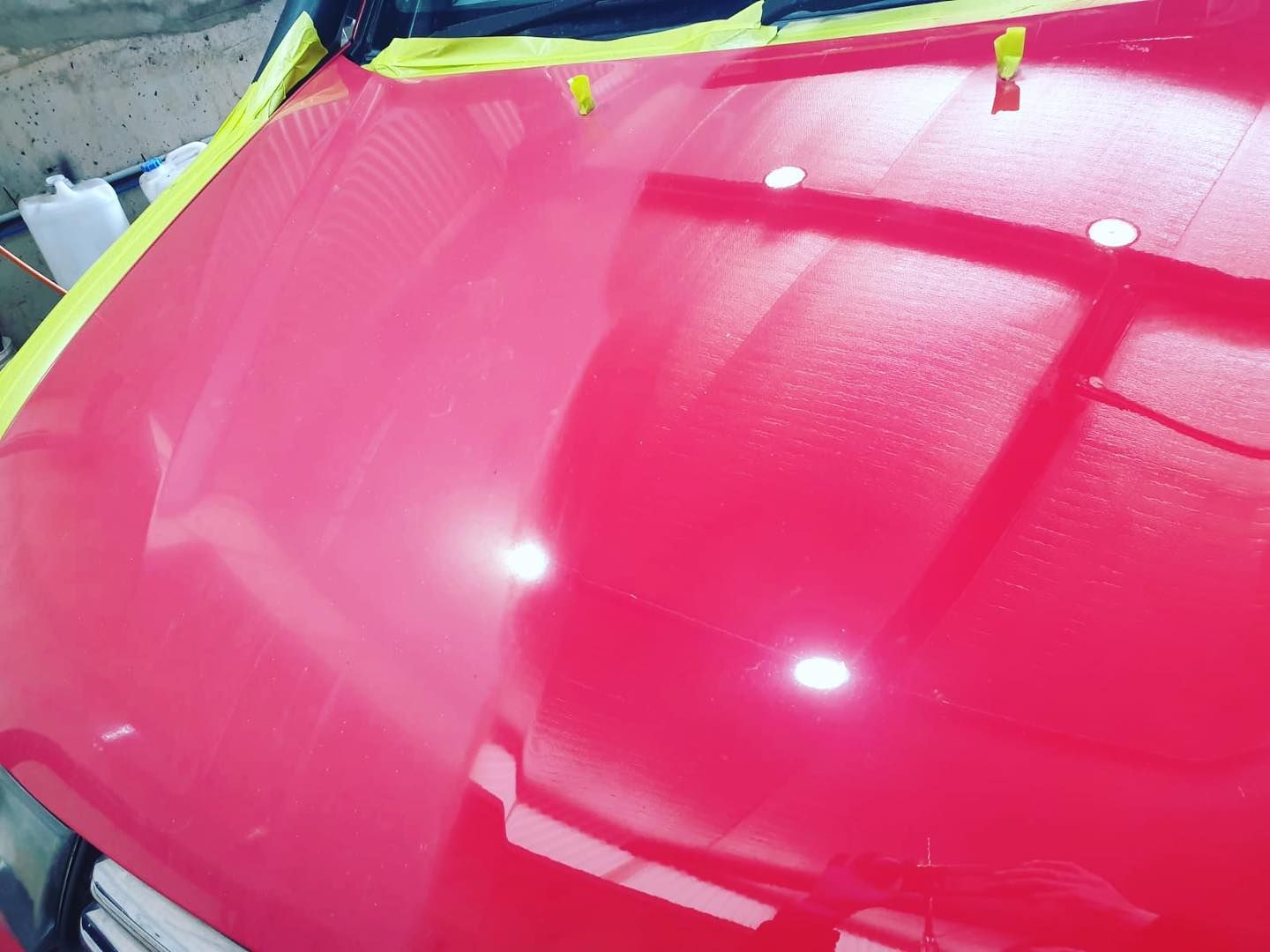 A Close up Of a Red Car Hood with Yellow Tape on It — Platinum Hand Car Wash & Detailing in Belconnen, ACT