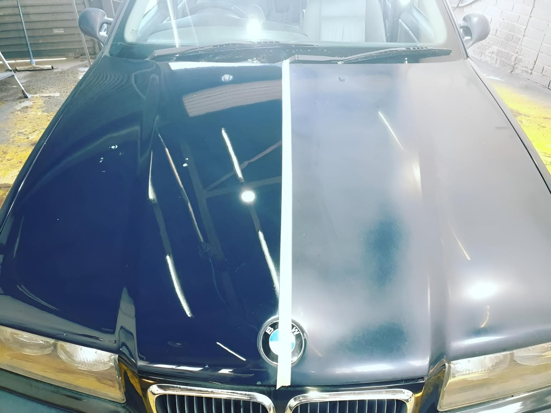 A Black Car with A White Line on The Hood Is Sitting in A Garage — Platinum Hand Car Wash & Detailing in Belconnen, ACT