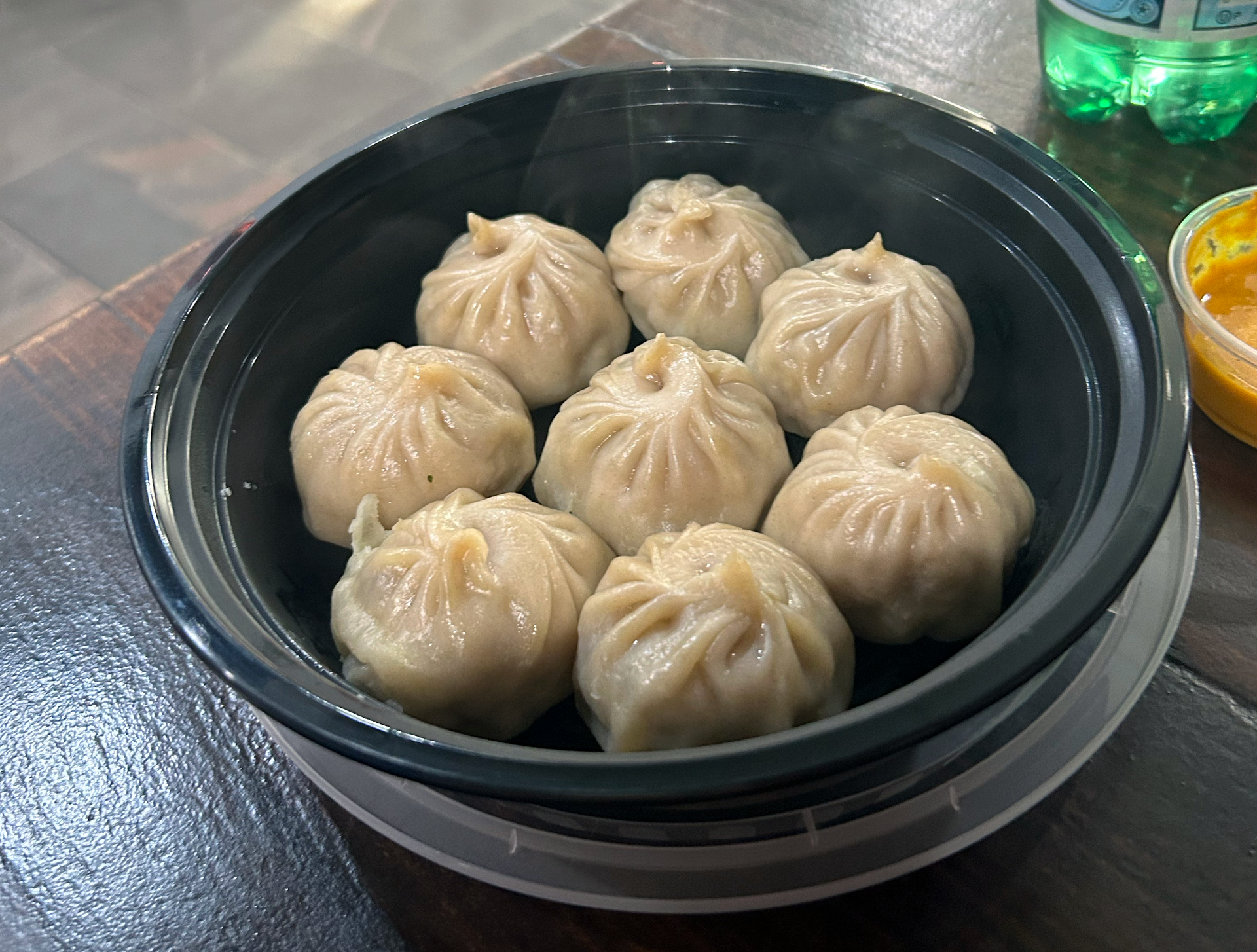 A bowl of dumplings is sitting on a wooden table.