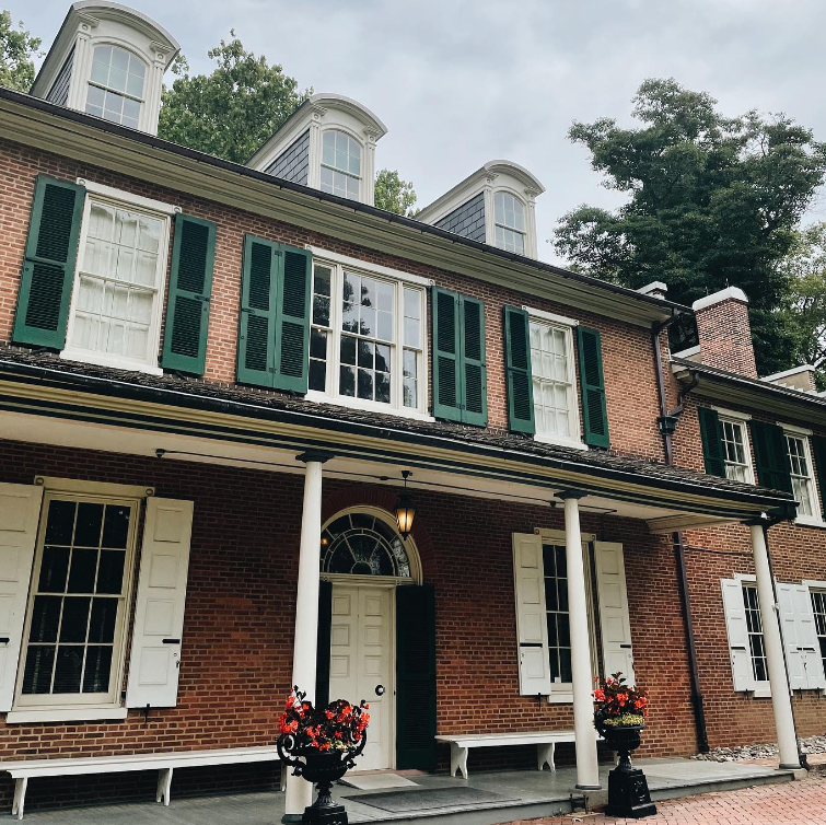 A large brick house with green shutters on the windows