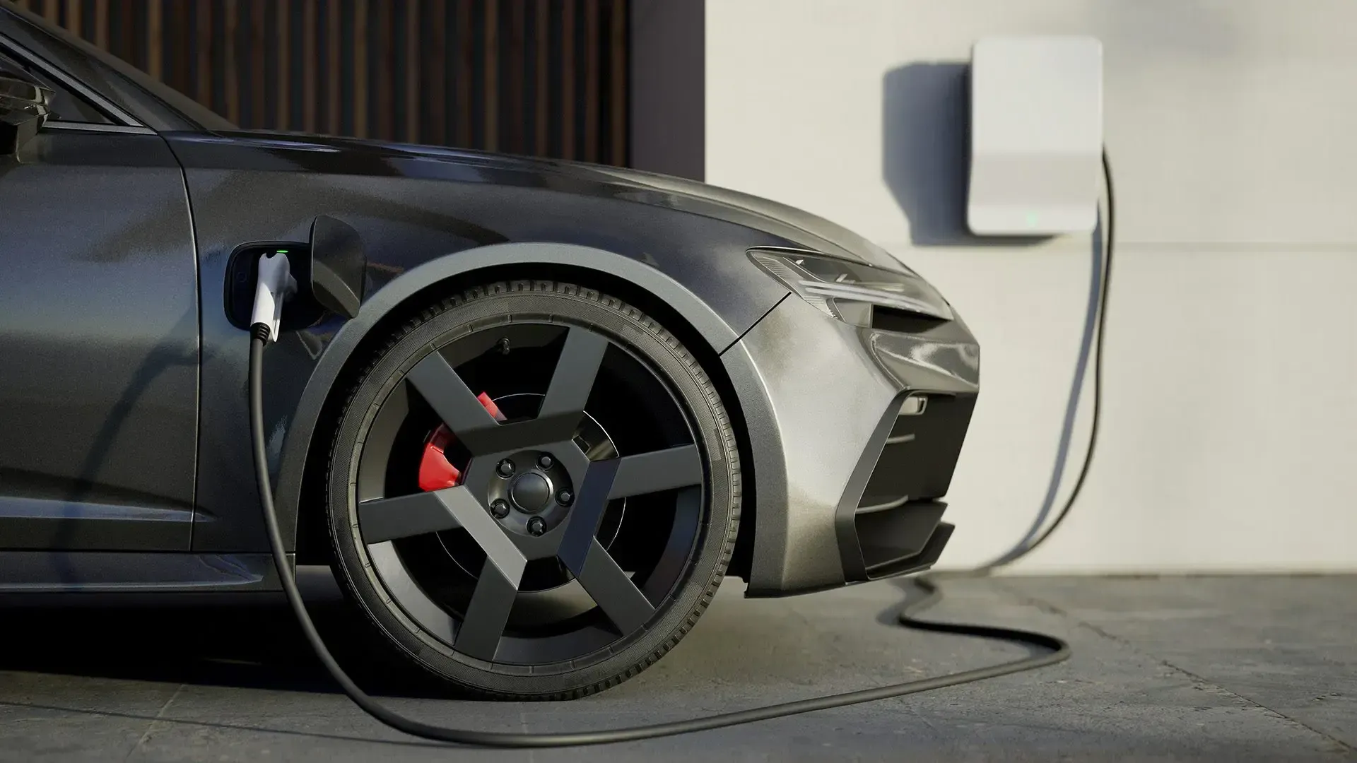 A black electric car is being charged at a charging station.