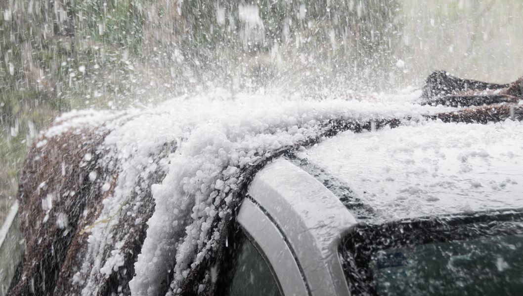 Snow and ice accumulation on a car roof during a snowstorm.