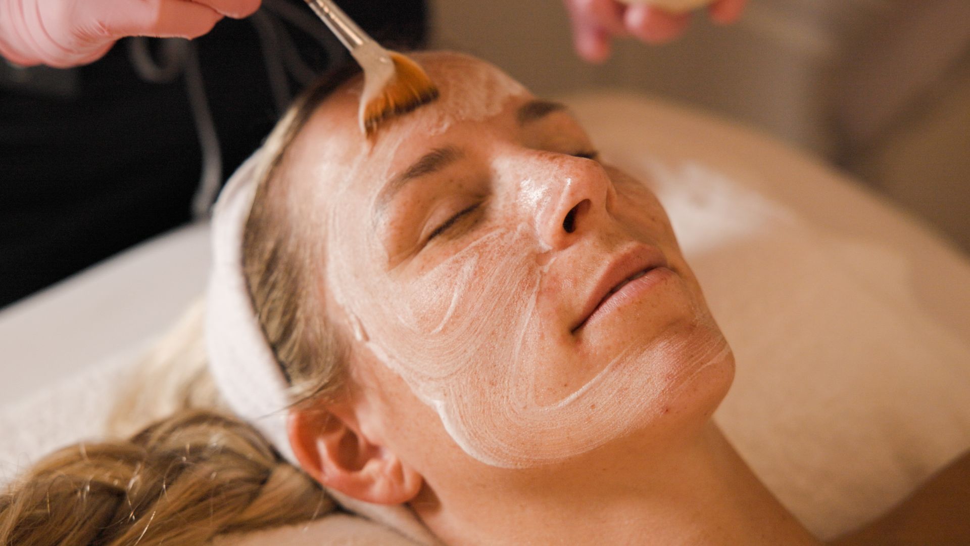 A woman is getting a facial treatment at a spa.