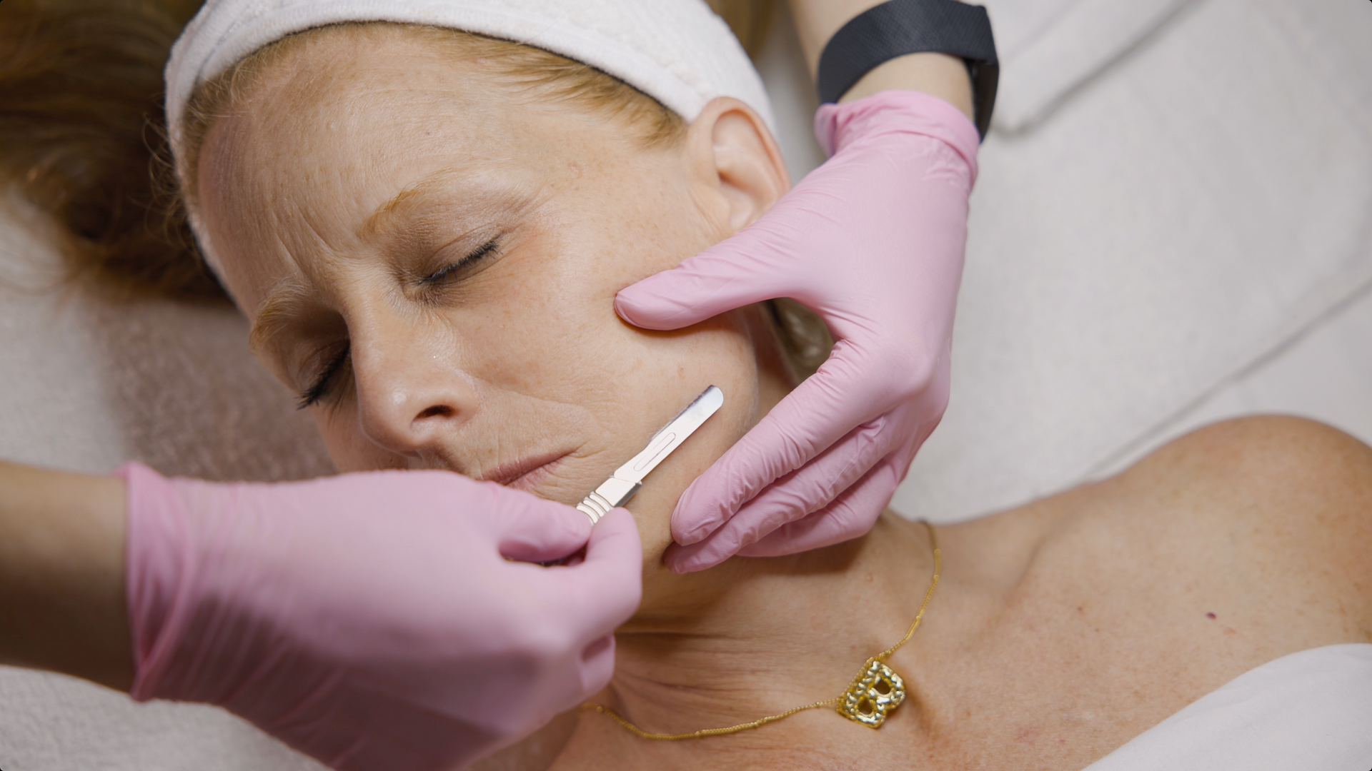 A woman is getting her face waxed at a beauty salon.