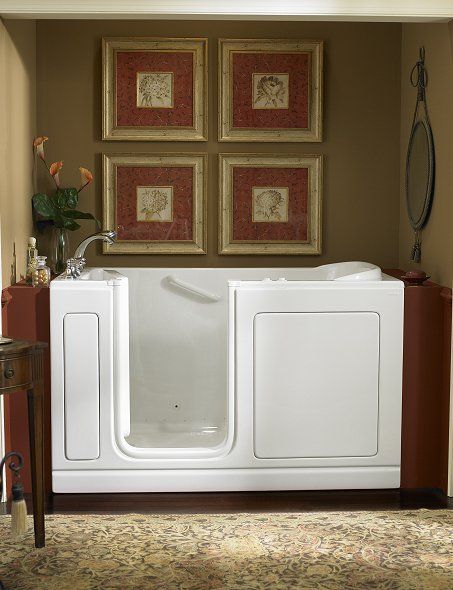 A bathroom with a walk in tub and four framed pictures on the wall