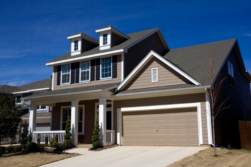 A large house with two garage doors and a porch