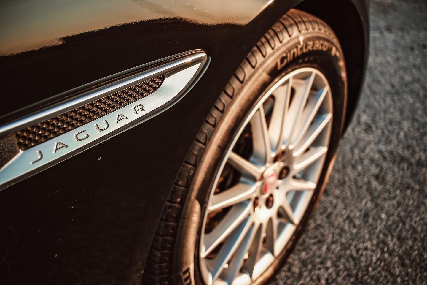un primo piano di un'auto Jaguar con un pneumatico sopra