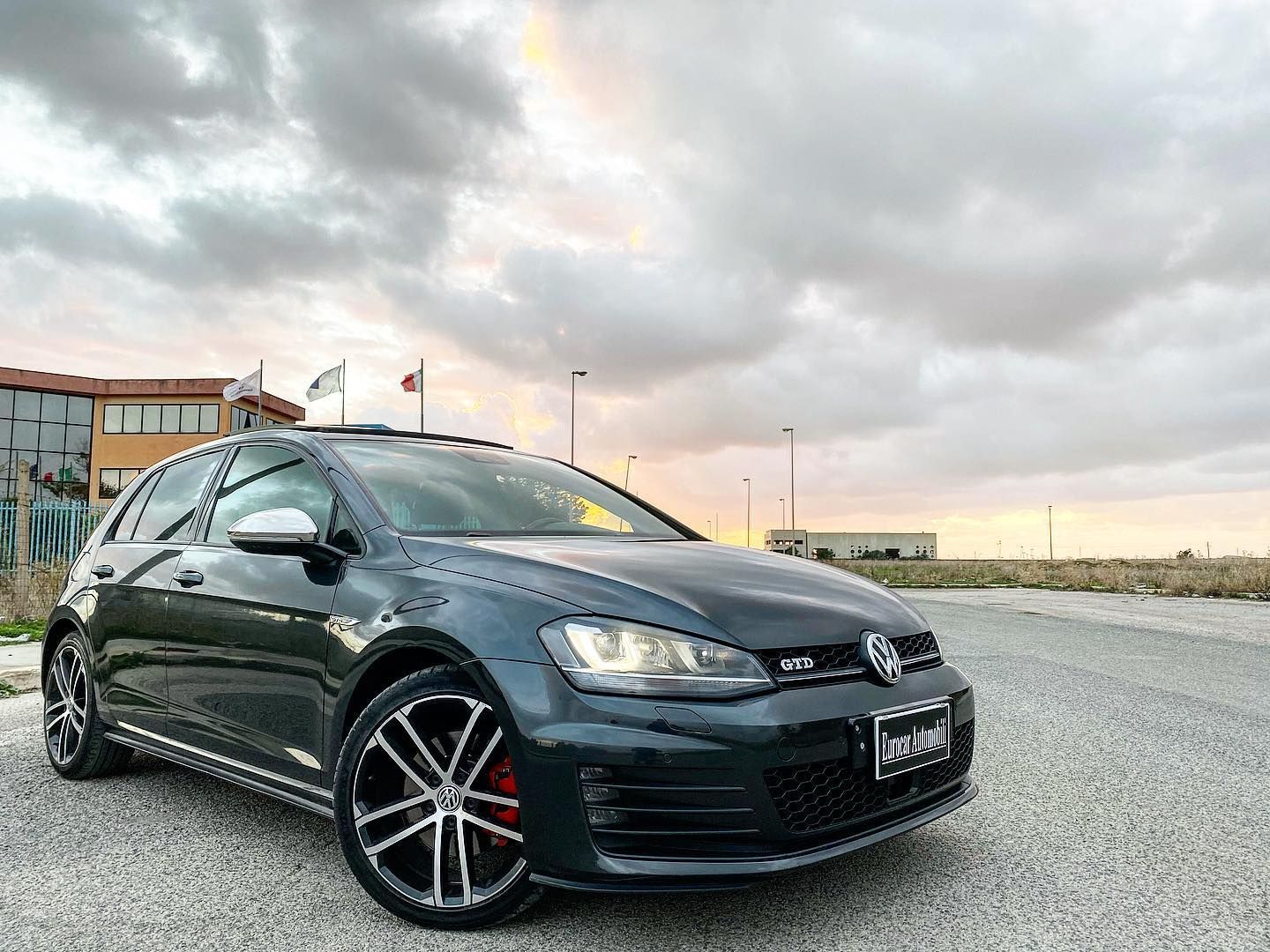 una Volkswagen Golf nera è parcheggiata sul lato della strada.