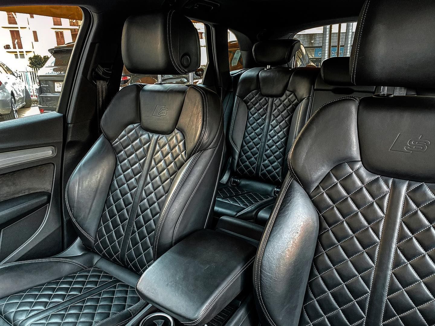 l'interno di un'auto con sedili in pelle trapuntata nera.