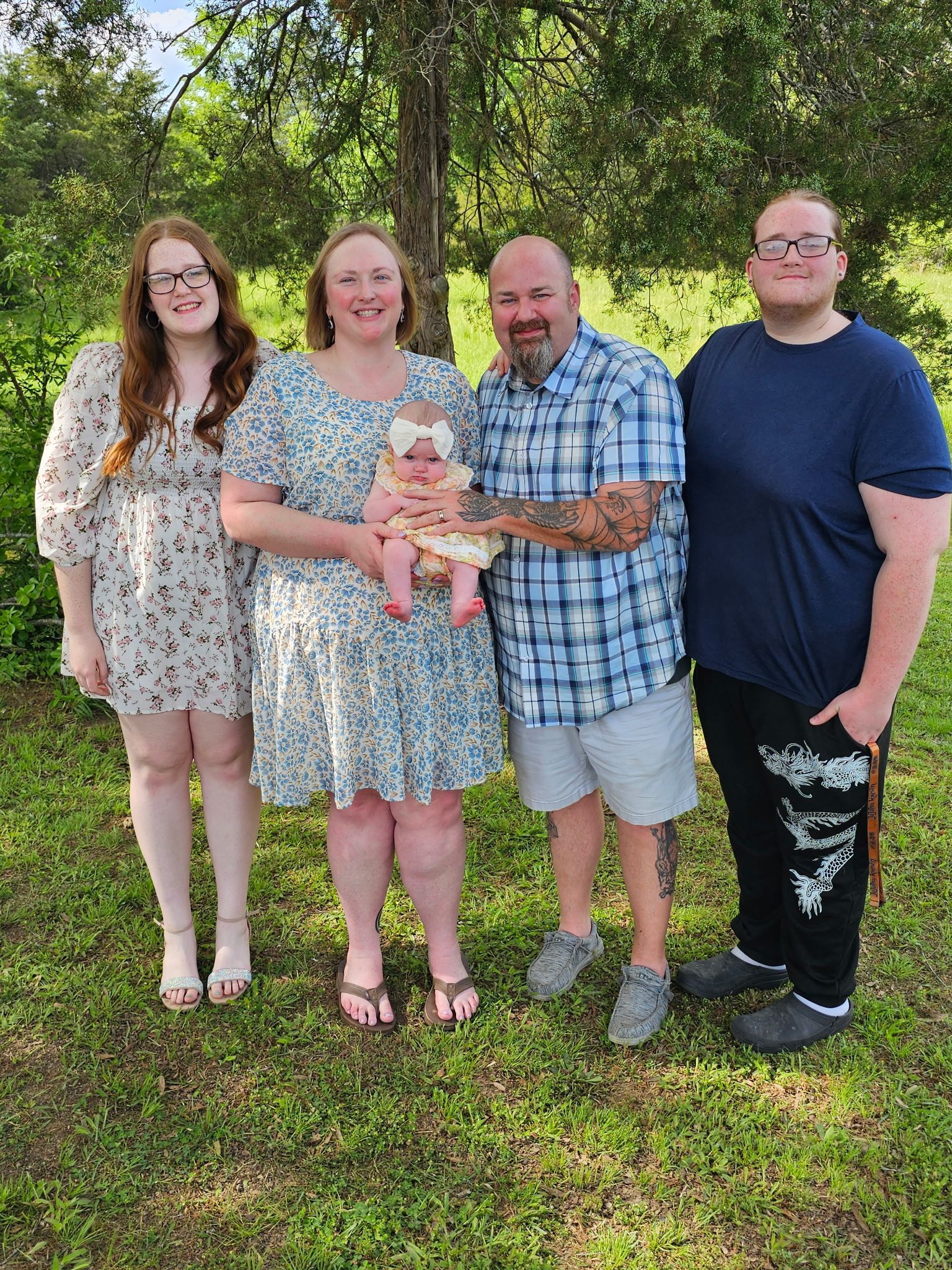 Dr Burton's family is posing for a picture together in the grass.
