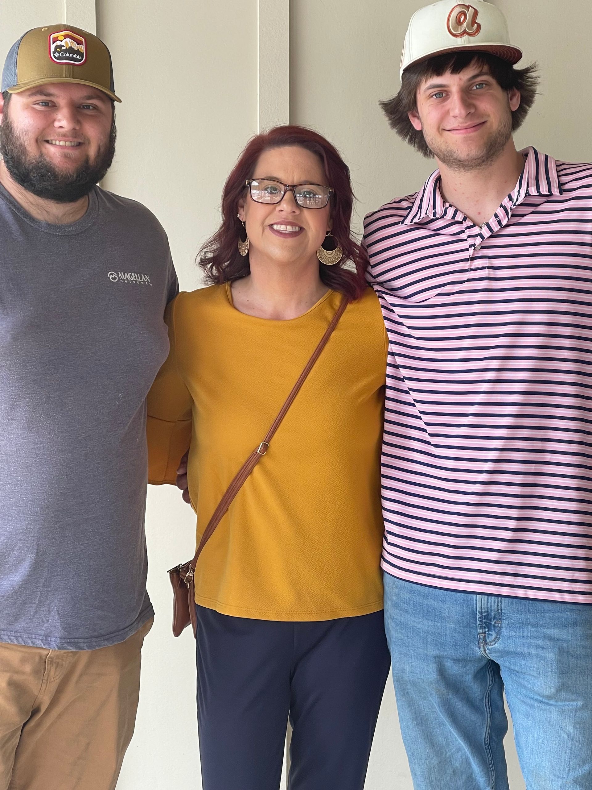 Two men and a woman are posing for a picture together