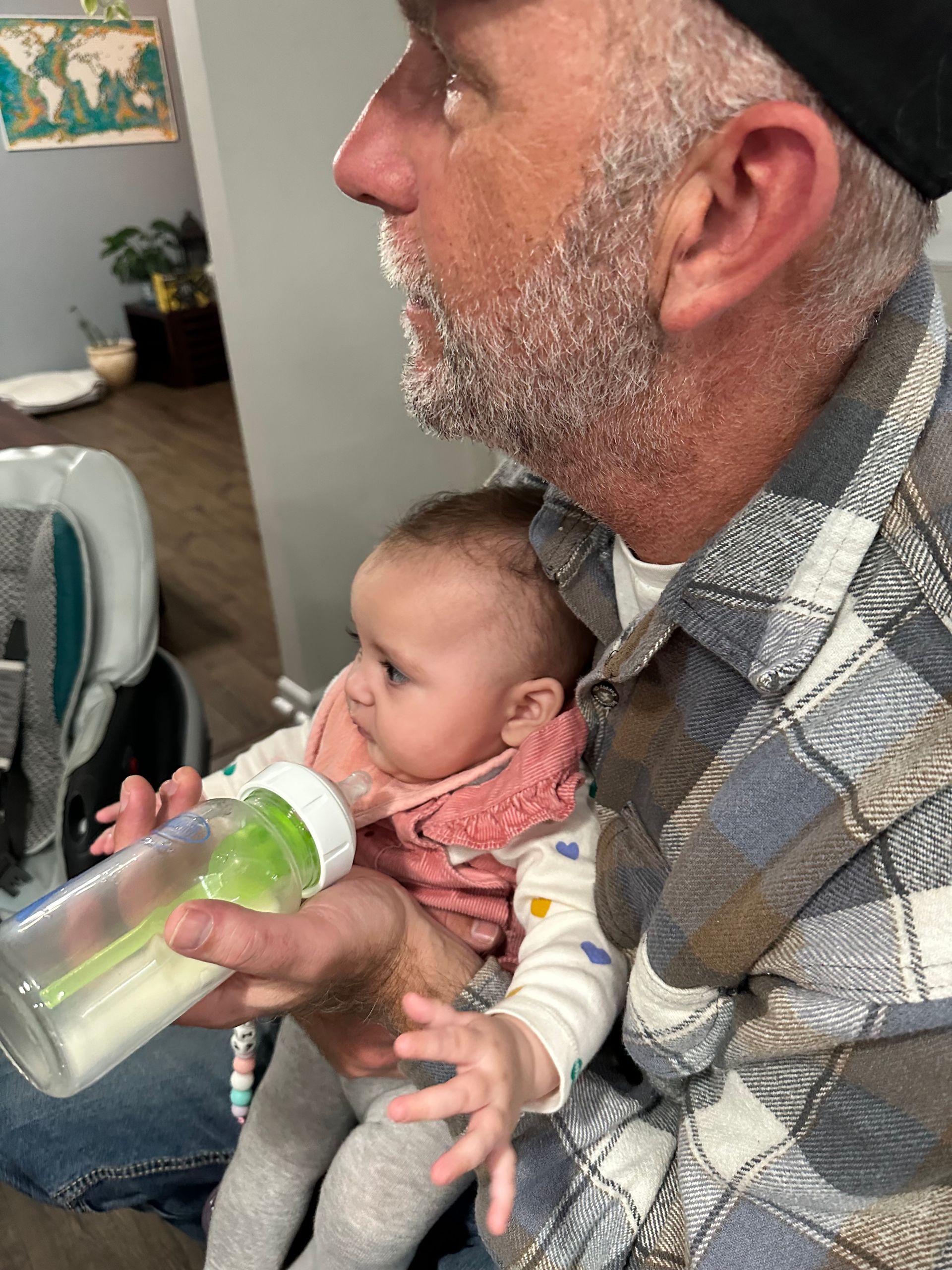 A man is feeding a baby from a bottle.