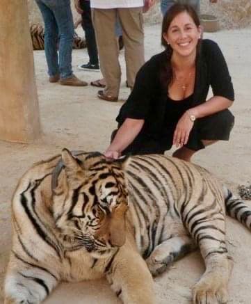 Dr. Love is kneeling next to a tiger.