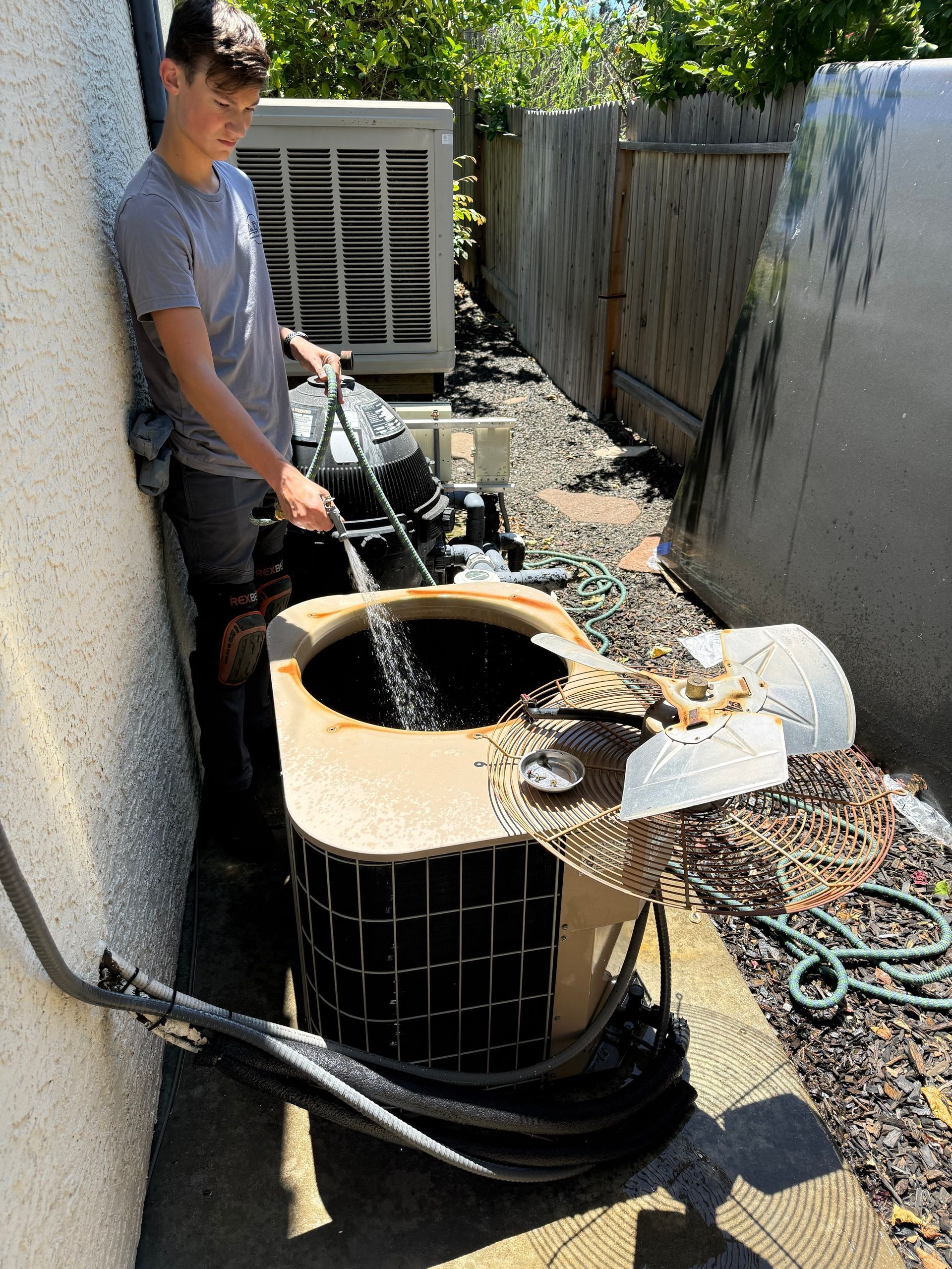 ARC technician performing an AC tune-up on a central air conditioning system in the Sacramento area