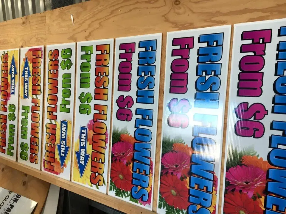 A bunch of signs that say fresh flowers on them