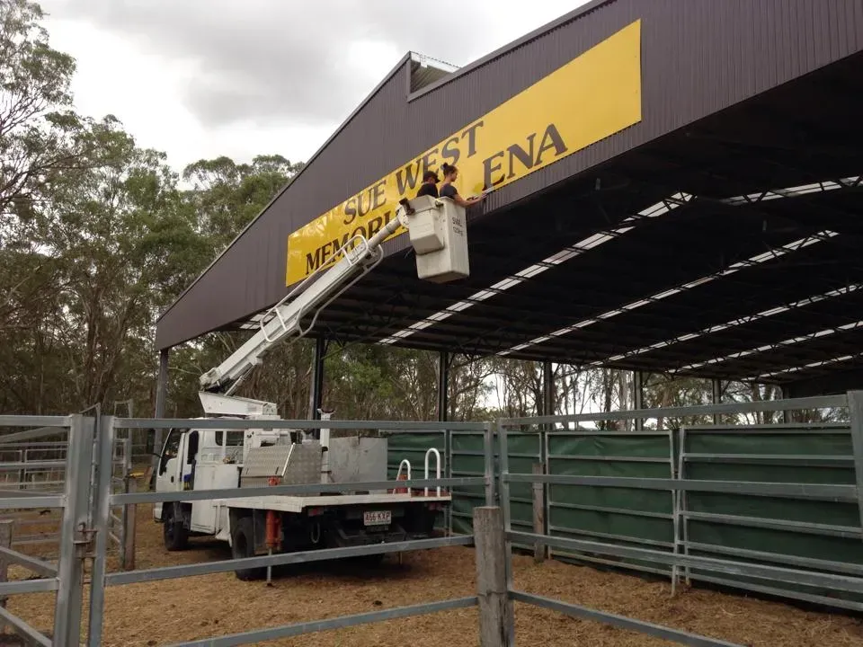 A white truck is parked in front of a building that says sue west lena
