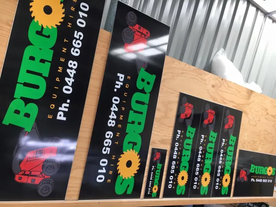 Several burgos signs are lined up on a wooden shelf