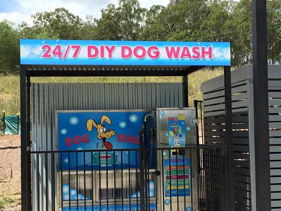 A fenced in area with a sign that says 24/7 diy dog wash