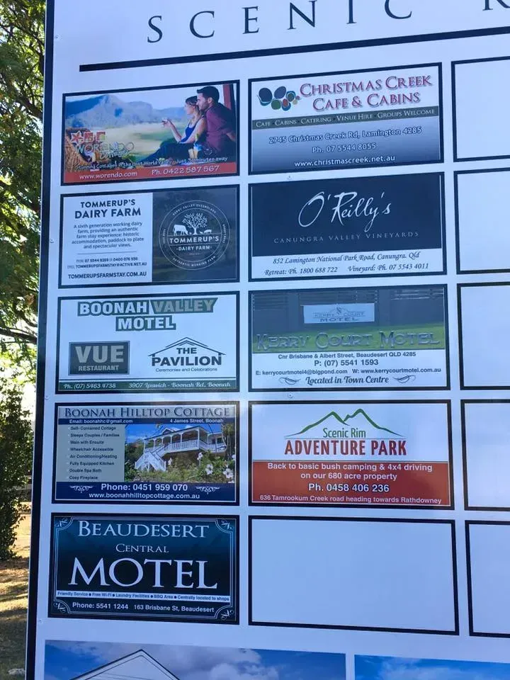A sign with a lot of advertisements on it including a motel