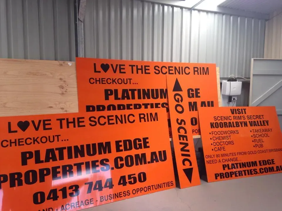A bunch of orange signs that say love the scenic rim