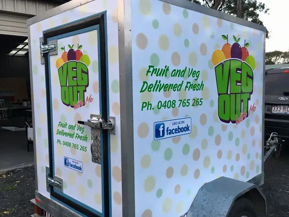 A trailer with a sticker on it that says fruit and veg delivered fresh