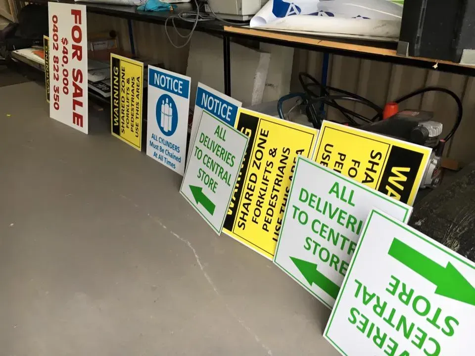 A bunch of signs on a table including one that says for sale