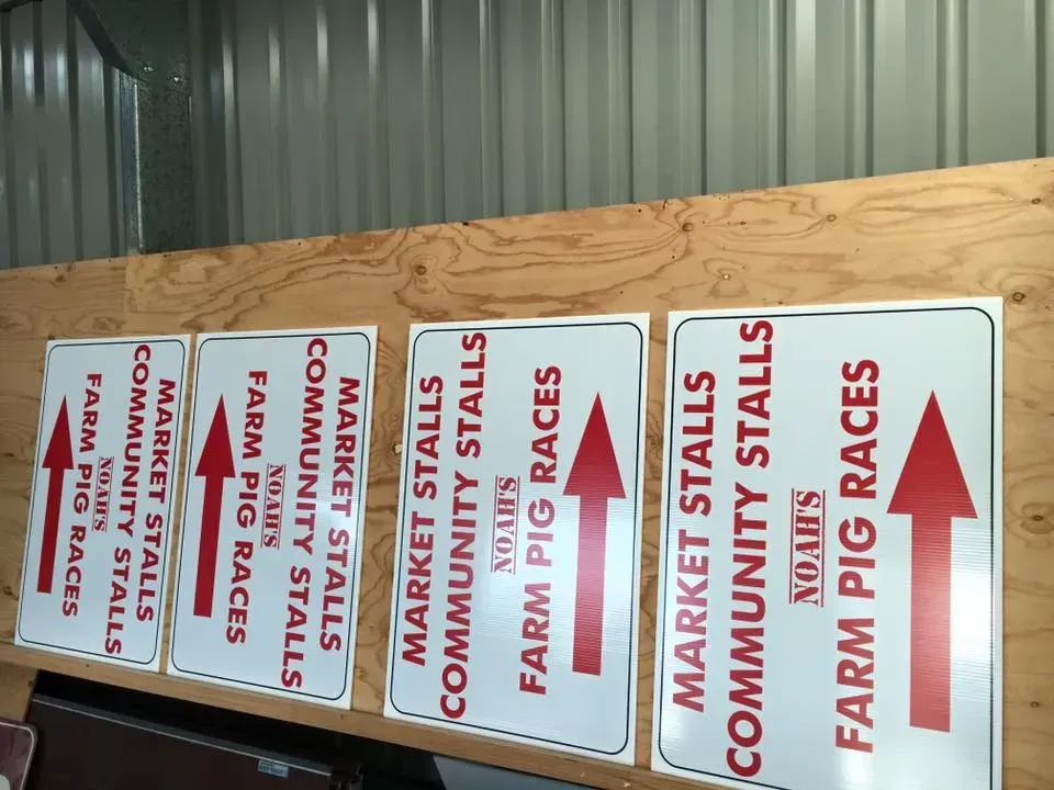 A row of farm pig races signs on a wooden wall