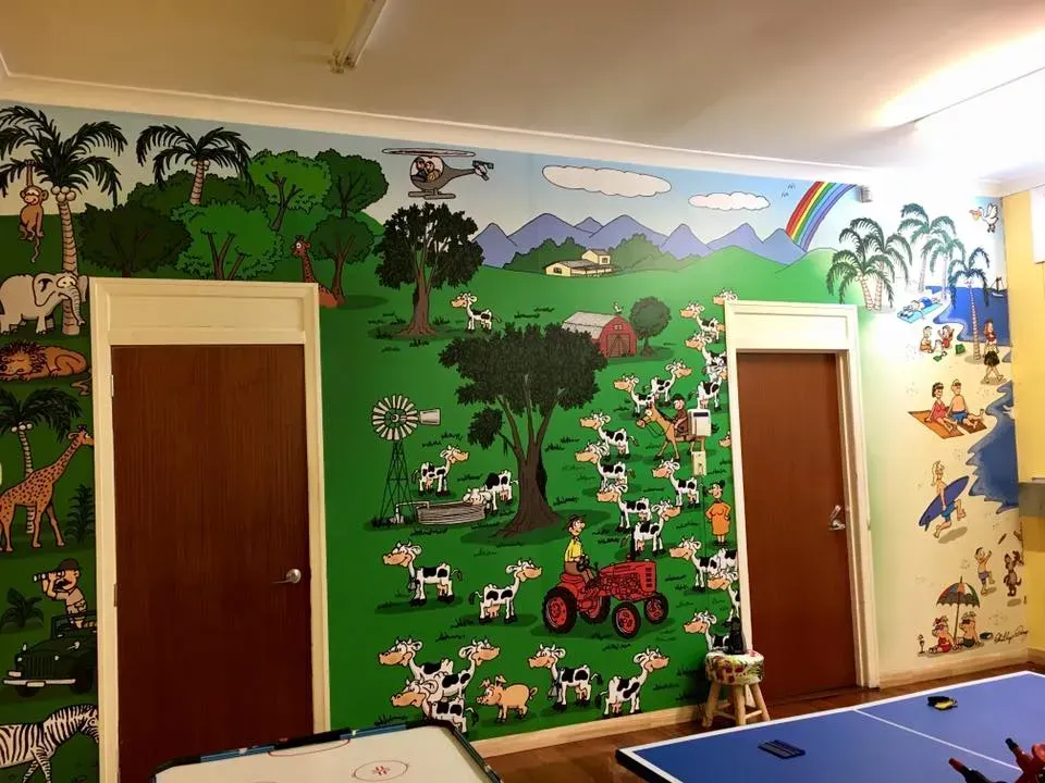 A room with a mural on the wall and a ping pong table