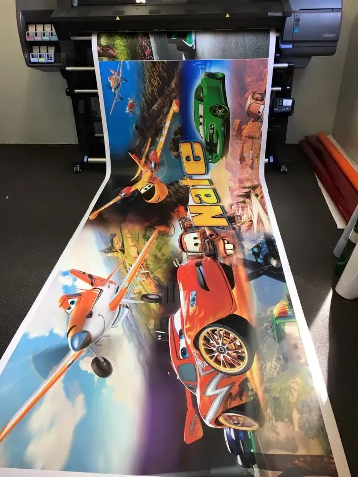 A poster of cars and planes is being printed