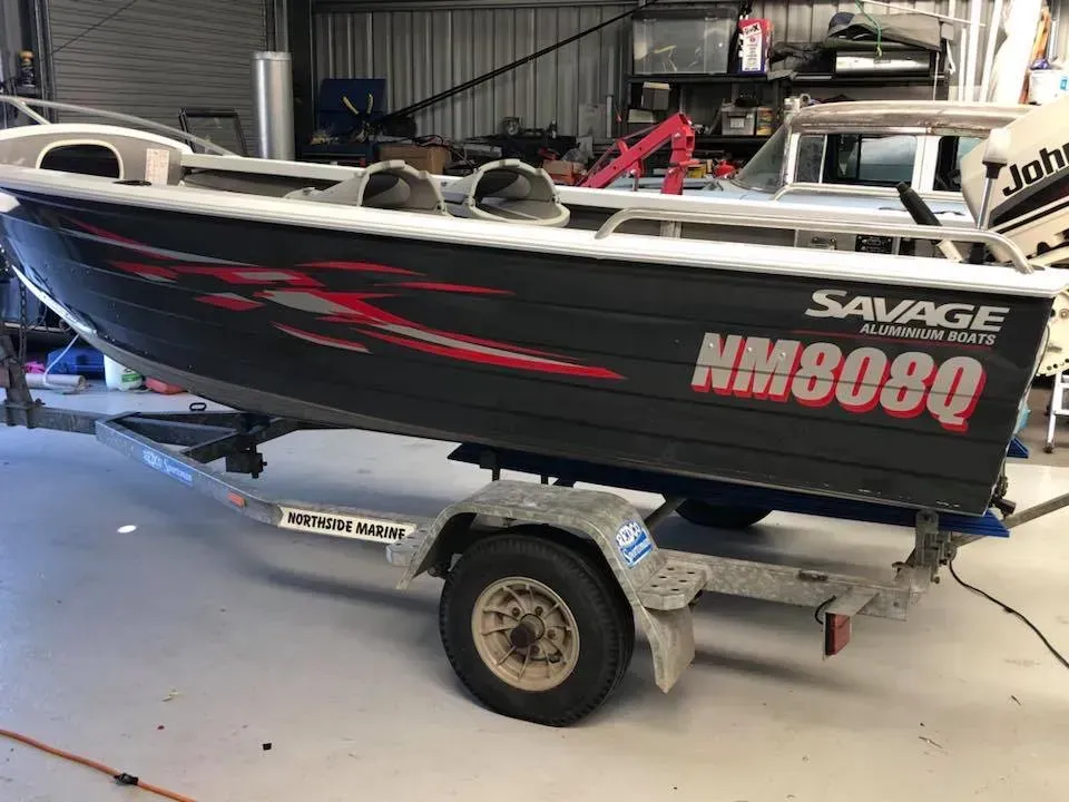 A boat is sitting on a trailer in a garage.