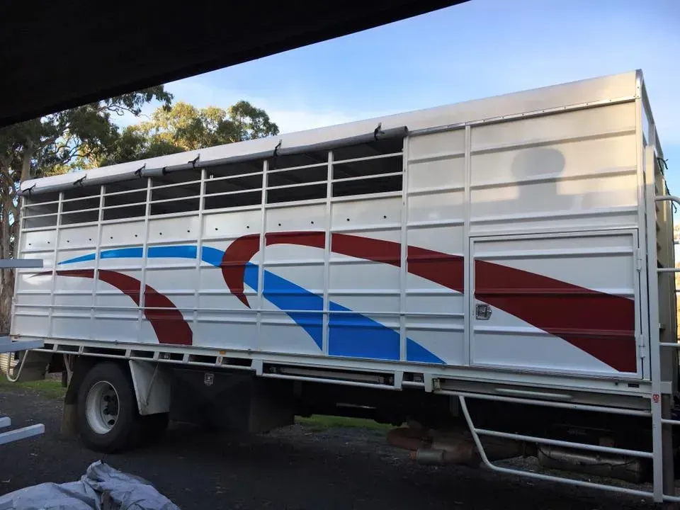 A red white and blue truck is parked on the side of the road