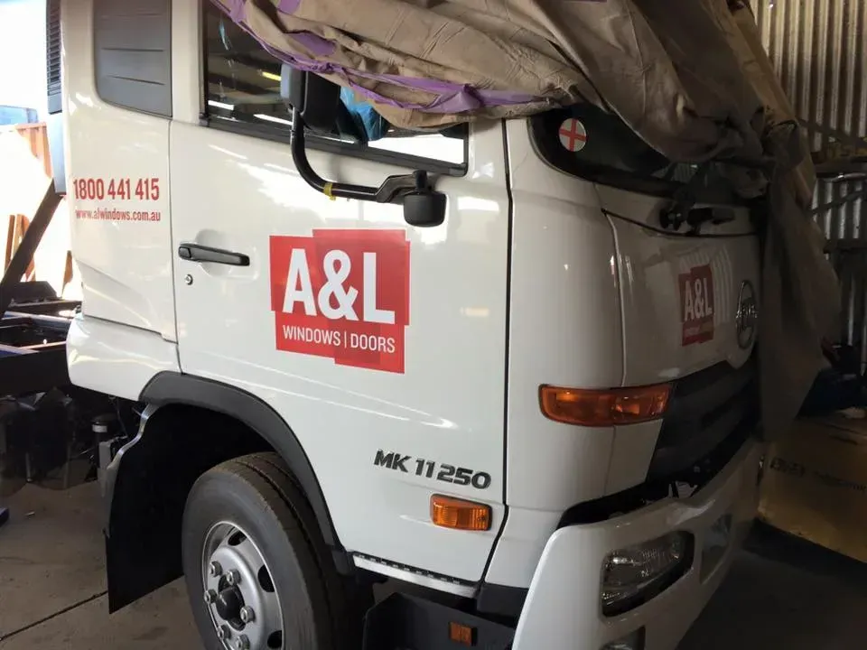A white a & l truck is parked in a garage