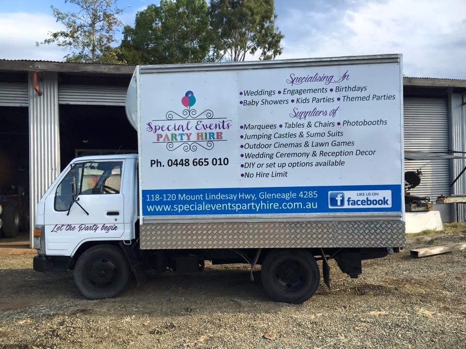 A special events party hire truck is parked in front of a building.