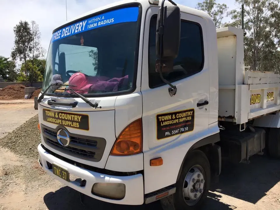 A white dump truck is parked on the side of the road.