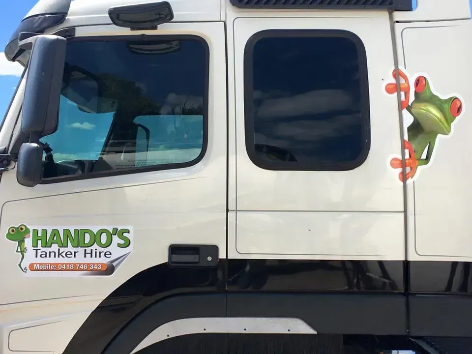 A white truck with a frog on the side that says hando 's tanker hire