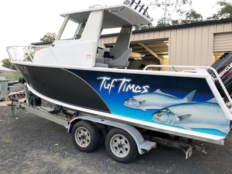 A boat on a trailer that says tuf times on it