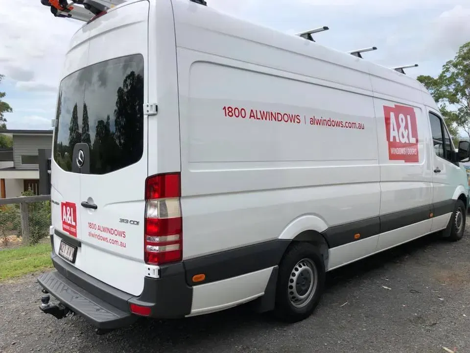 A white van is parked on the side of the road.